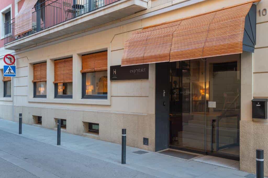 Hotel Es Portalet entrance with bamboo awnings on a city street.