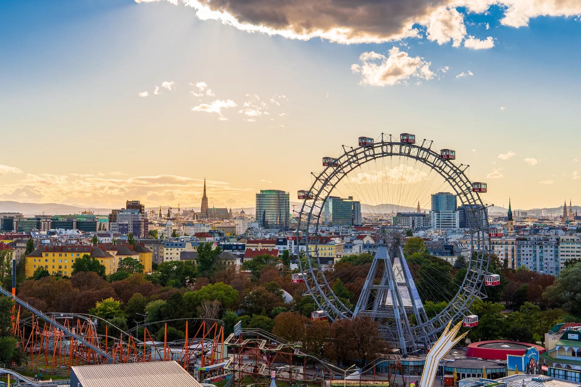 Giant Ferris wheel at Vienna Prater amusement park overlooking city skyline at sunset