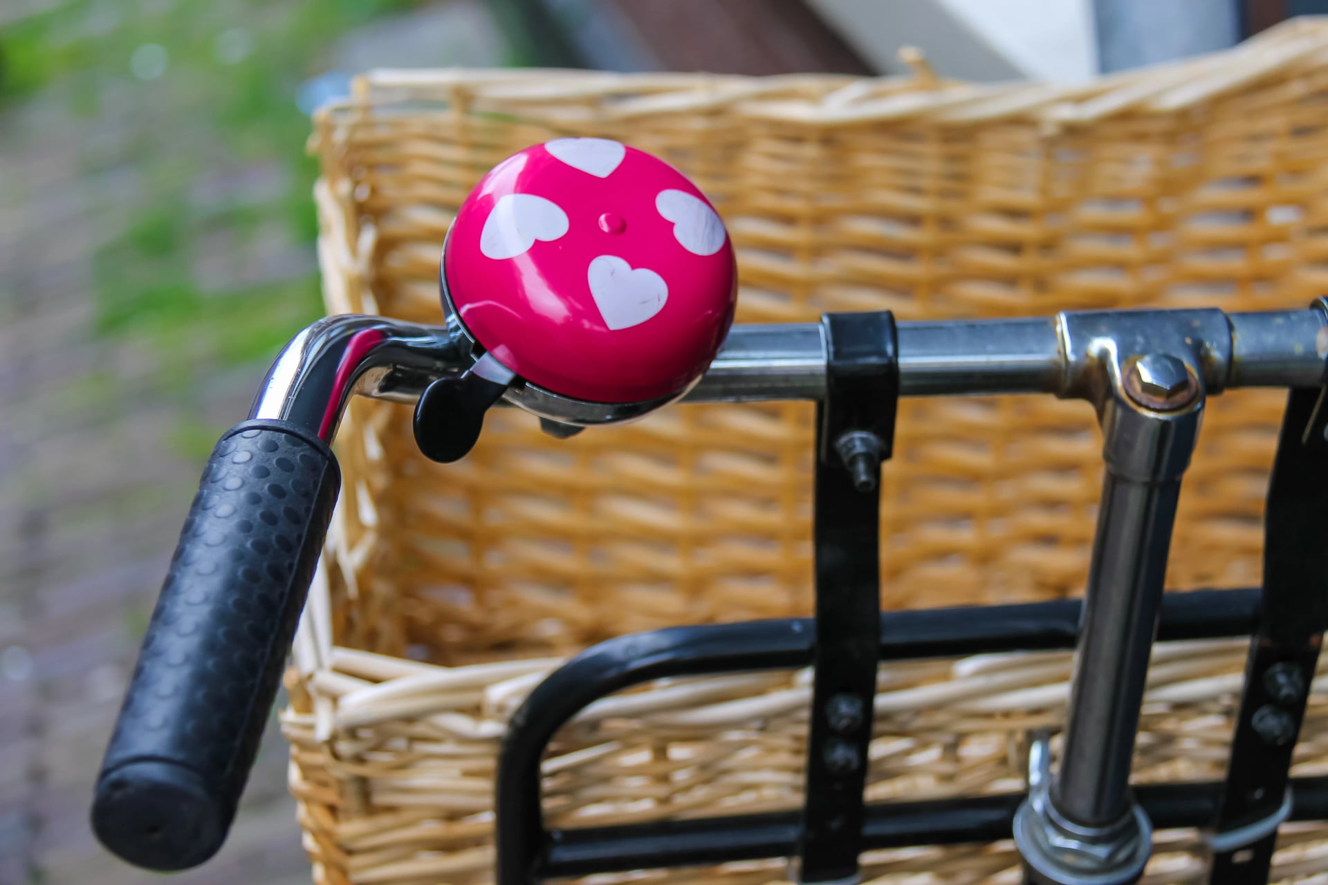 Pink bicycle bell with white hearts on handlebars