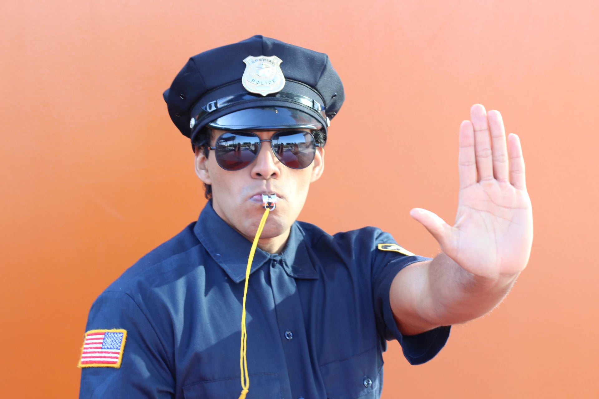 Stern police officer blowing a whistle 