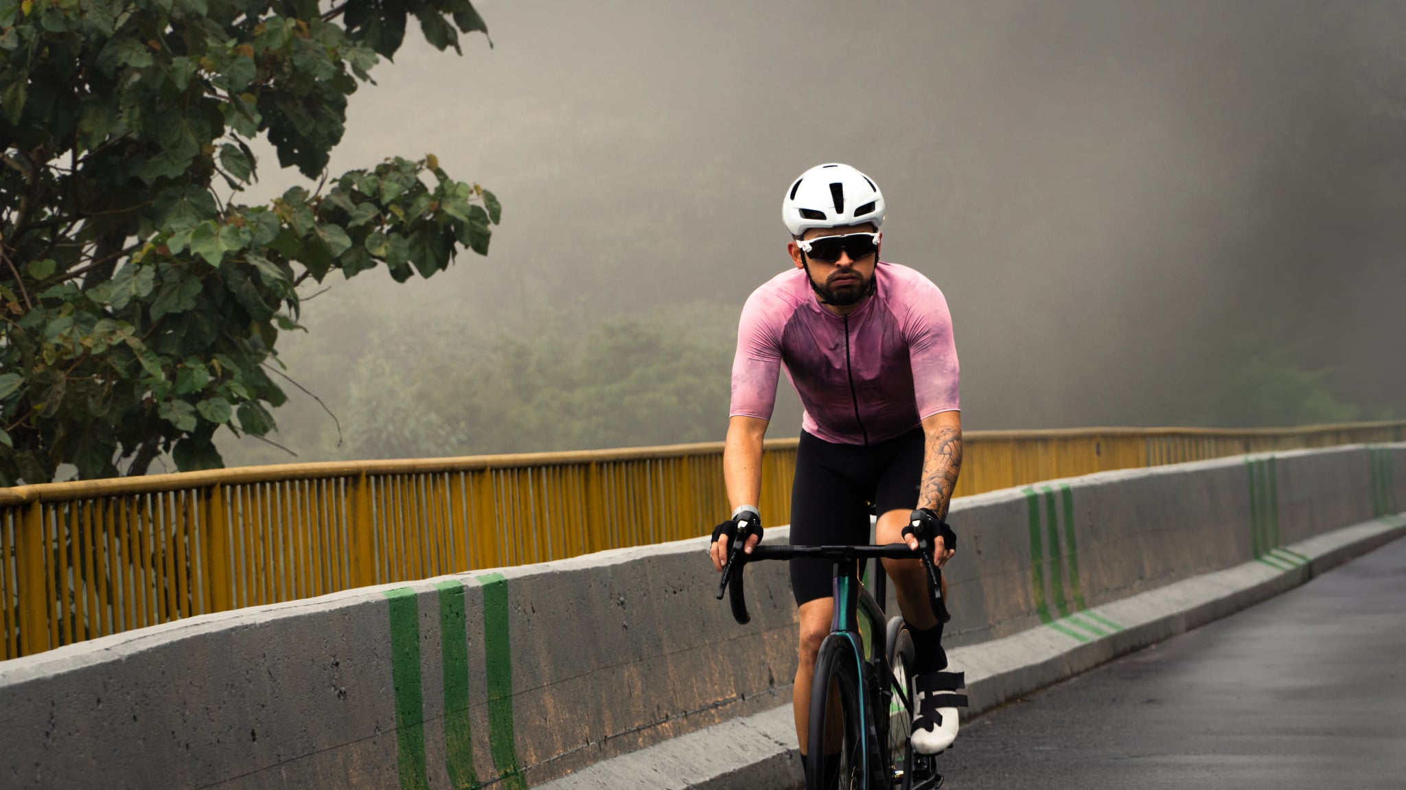 professional cyclist training cycling sighing from fatigue on a foggy morning