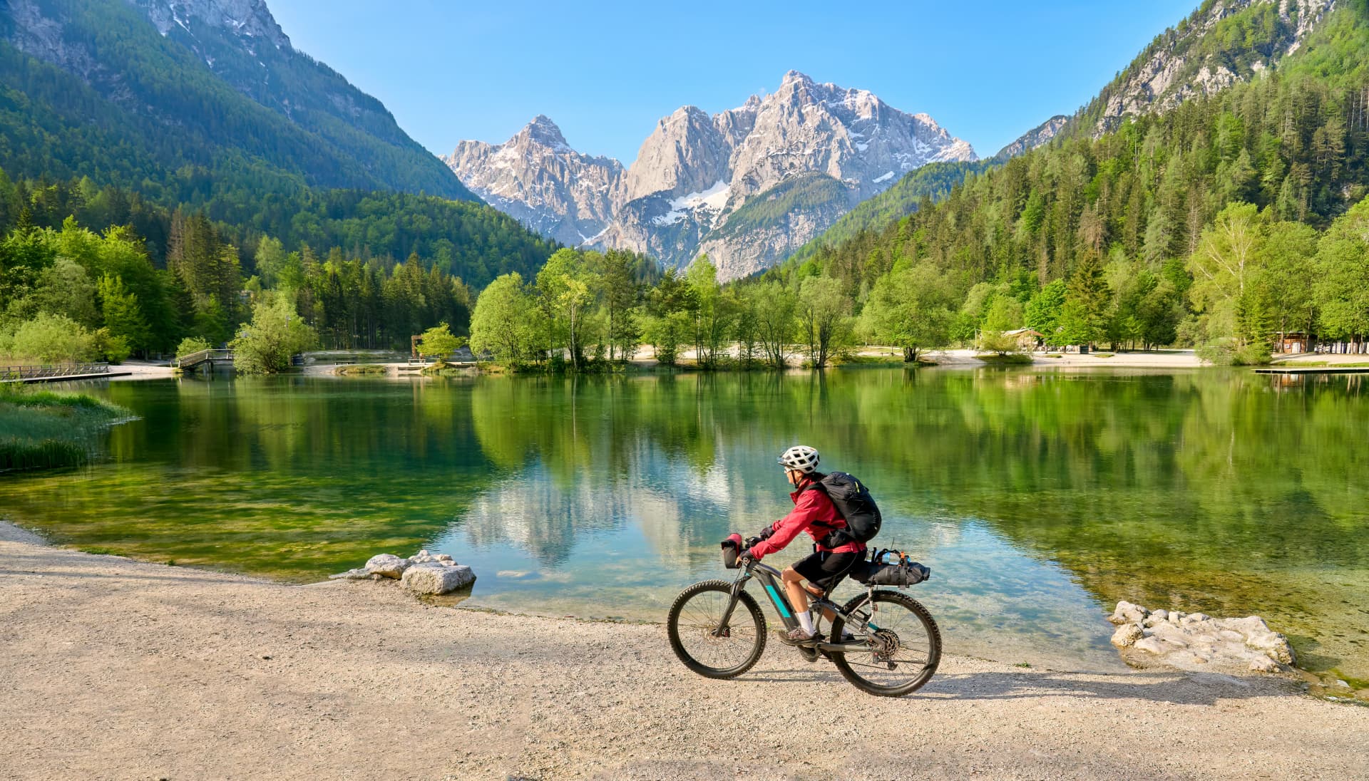 active senior woman on a mountain bike tour at Lake Jezero Jasna in the Triglav National Park near Kranska Gora, Julian Alps, Slovenia